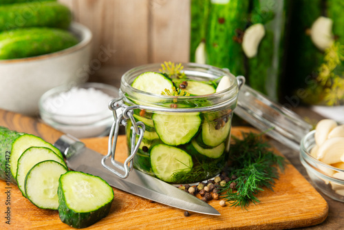 Cuadro en lienzo Freshly-salted homemade cucumbers in a jar on a wooden background