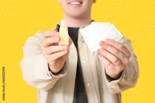 Young man with sanitizer an...