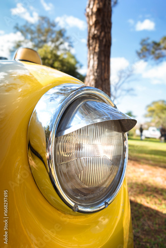 Cuadro en lienzo Classic front headlight with chrome trim on a yellow car.