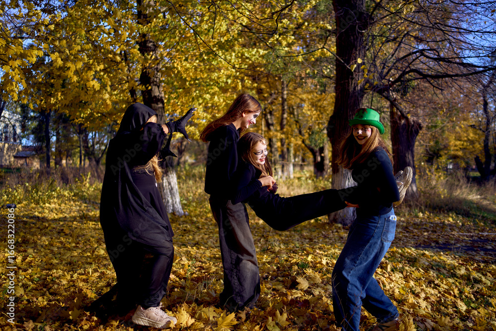Naklejka premium Teenage friends with stage makeup of a mime during an acting lesson celebrate Halloween in the park near the school, act out scenes and have fun