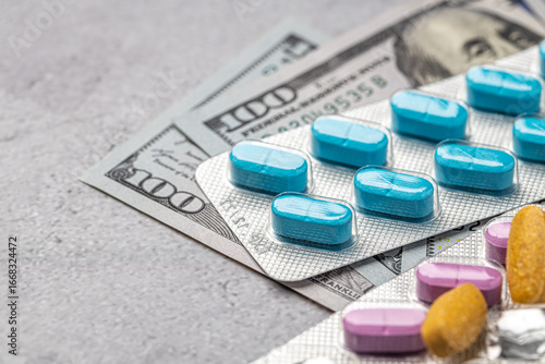 Dollar bill and a set of medicine pills. Rising costs of medical care. Reliefs for buying medicine.Pills in capsules scattered on US dollars currency.Concept of health care in USA.