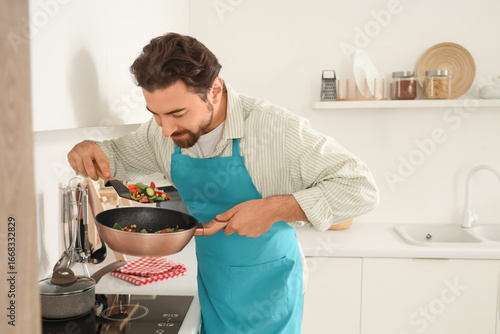 Handsome bearded man frying...