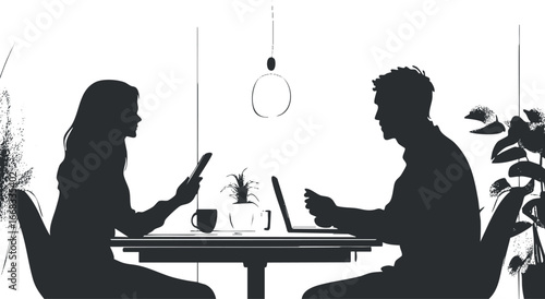 Silhouette of a man and woman sitting at a table indoors using a laptop and phone, communicating.