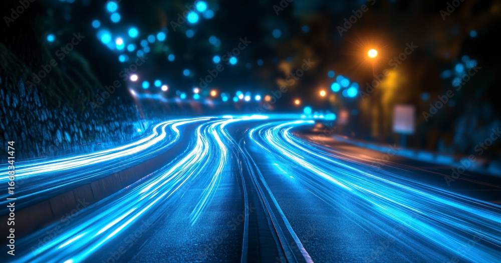 Fototapeta premium Long exposure of a winding road at night with vibrant blue light trails
