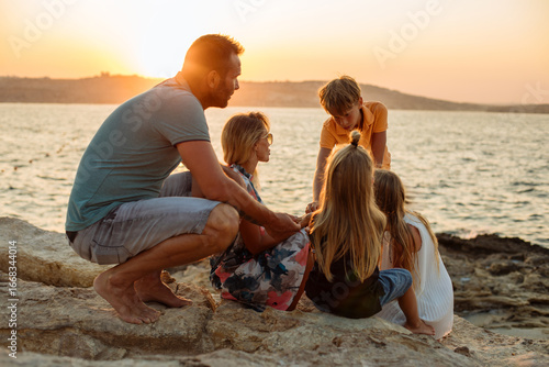 Family playing together seaside.
Family playing together seaside and having a good time with their children's. Lots of love and fun, at a beautiful golden hours time.