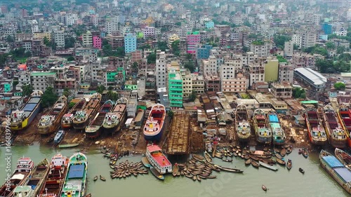 Dhaka, Bangladesh - 23 August 2025: Aerial view of numerous boats docked near buildings, creating a vibrant contrast of maritime and urban landscapes.