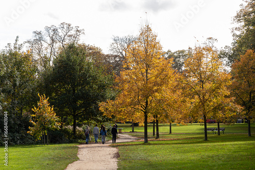 Cambridge, England. Walkways and gardens of King's College with autumn foliage and green lawns, part of the historic college grounds beside the River Cam