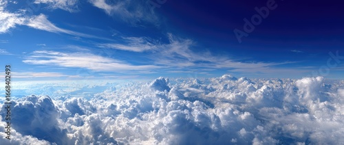 Panoramic view of a vast, fluffy cumulus cloud sea beneath a vibrant blue sky, wispy cirrus clouds streaking across the upper atmosphere