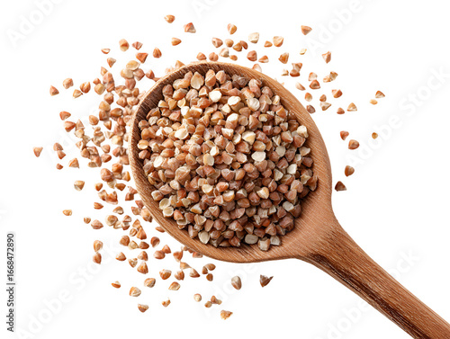 Buckwheat groats in a wooden spoon on black background