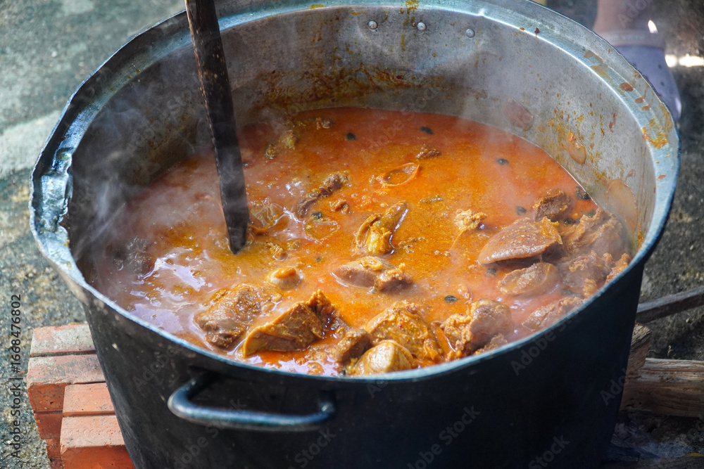 Φωτογραφία Aromatic steam rises from a large pot filled with a simmering stew, stirred by a wooden utensil