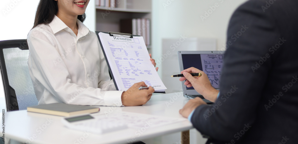 Fototapeta premium Asian woman attending job interview and showing resume to hr manager, talking about her profile and experience for job opportunity in office.