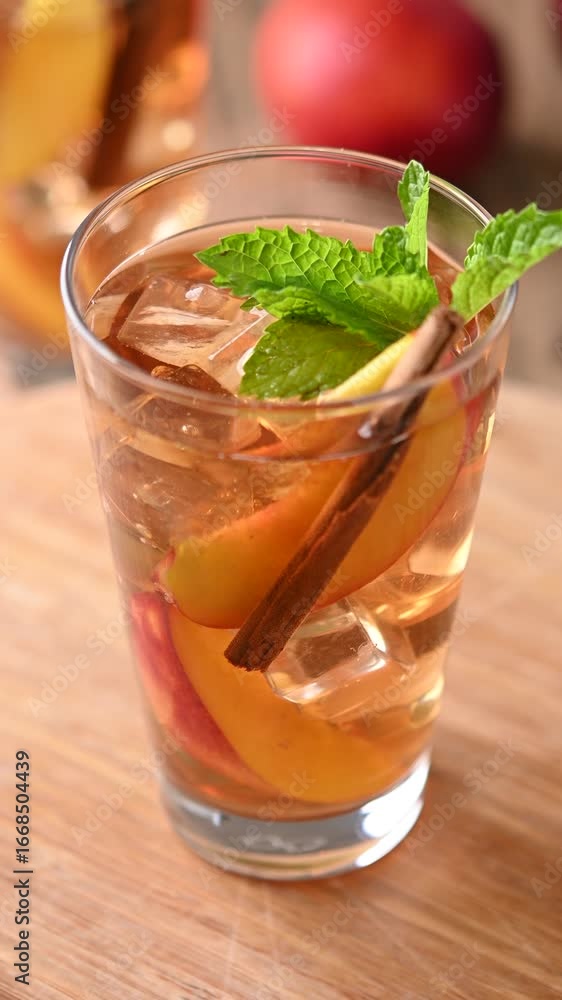 Refreshing peach iced tea in glass with ice cubes and cinnamon Refreshing peach iced tea in glass with ice cubes and cinnamon