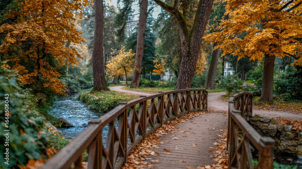 Obraz premium Scenic wooden bridge over a tranquil stream surrounded by vibrant autumn foliage, inviting pathways, and lush greenery, creating a serene natural landscape