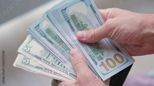 Man Pulls Out Dollars from Wallet