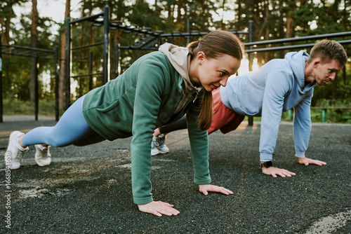 Fotografia Caucasian young woman and Caucasian young man exercising outdoors performing pus