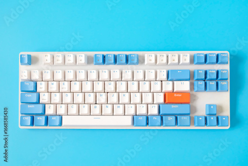 Computer keyboard on blue background. Top view