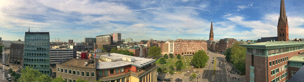 Fototapeta premium Panoramic cityscape view with buildings, spires, and blue sky under calm conditions