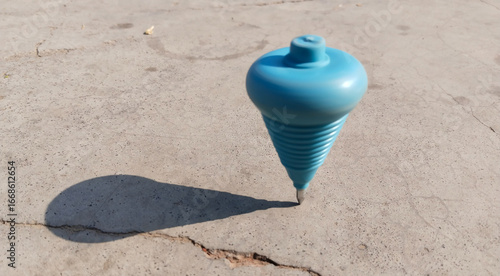 Spinning lattu captured mid-motion on ground, representing traditional Indian childhood toy in action with dynamic blur, cultural nostalgia, and rural entertainment concept