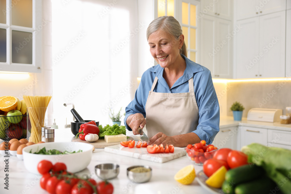 Senior woman cooking at white marble table in kitchen Senior woman cooking at white marble table in kitchen