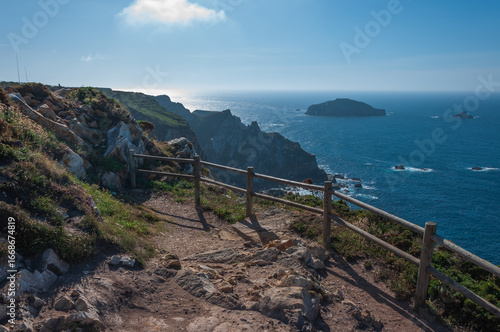 Acantilado marino en día soleado con valla de madera sin gente
