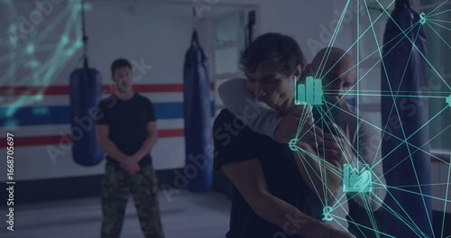 Tableau sur toile Demonstrating instructor applying hold on student in martial arts dojo with punc