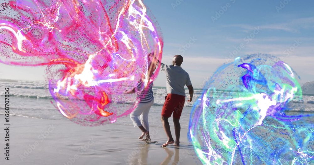 Fototapeta premium Dancing mature couple reaching toward swirling energy orbs at beach shore, with pink and blue hues