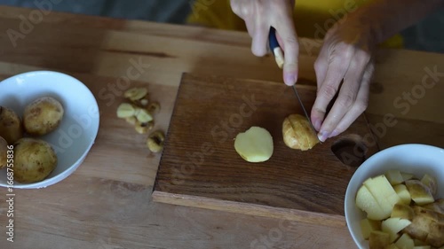 Hands skillfully cutting potato slices on rustic wooden cutting board during video home preparation cooking fullhd