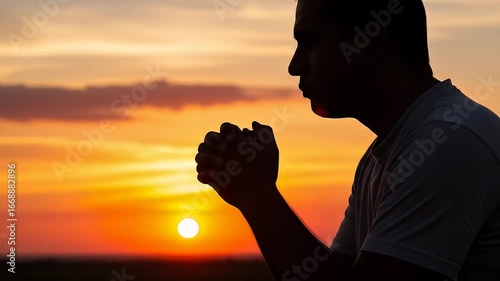 Silhouette of Man Praying During Golden Hour Sunset with Warm Tones Sky in Outdoor Setting Seeking Faith and Hope with Spiritual Connection