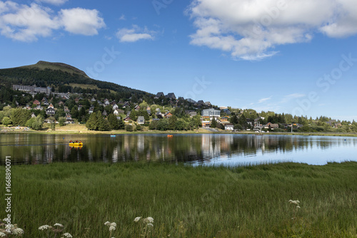 Summer evening view with beautiful light, of Lac des Hermines (lake) at Super Besse ski resort, near Besse-et-Saint-Anastaise, in France. Copy space above and below.