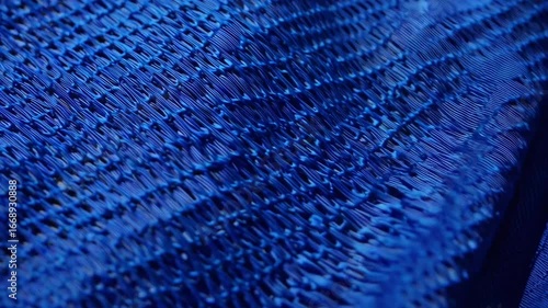 textured surface composed of azure-colored athletic fabric typically used for football uniform tops.