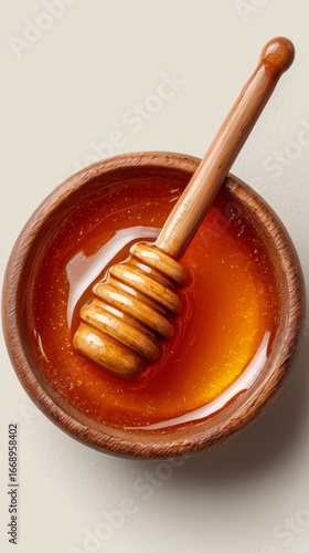 Golden Honey in Wooden Bowl With Honey Dipper and Drizzles on Light Background.