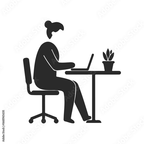 Silhouette of female working on laptop at desk with plant