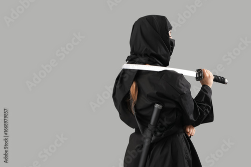 Tableau sur toile Female ninja with sword on grey background