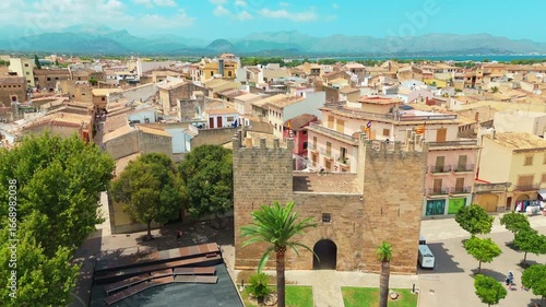 Aerial view Alcudia, SPAIN the vibrant landscape showcasing historic architecture, lush greenery, and scenic coastline, illustrating the beauty of a Mediterranean town in motion