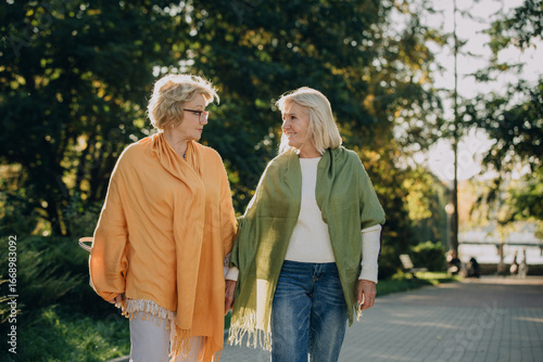 Obraz na plátně Two senior women enjoying a relaxing walk in the park