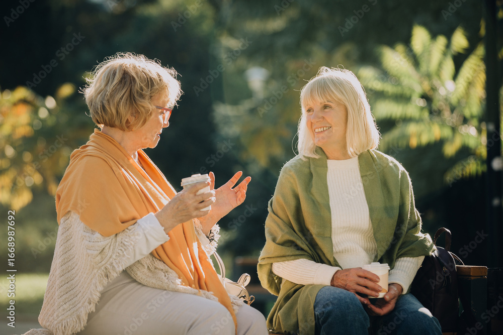 © dsheremeta - Two senior women enjoying coffee and conversation in park