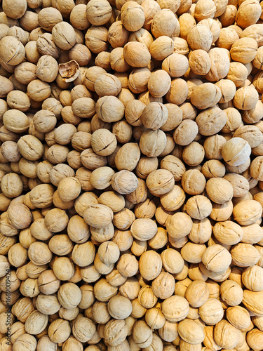 Various types of unprocessed nuts displayed at a market, showcasing the natural texture and color of the shells