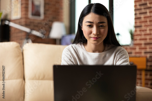 Fotografia Portrait of female business consultant looking at device screen with focused expression, remotely updating company statistics