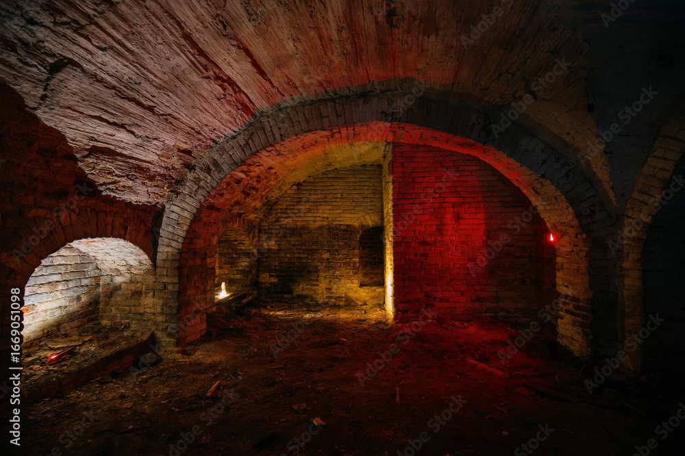 Fototapeta premium Dark and creepy vaulted red brick cellar under old castle