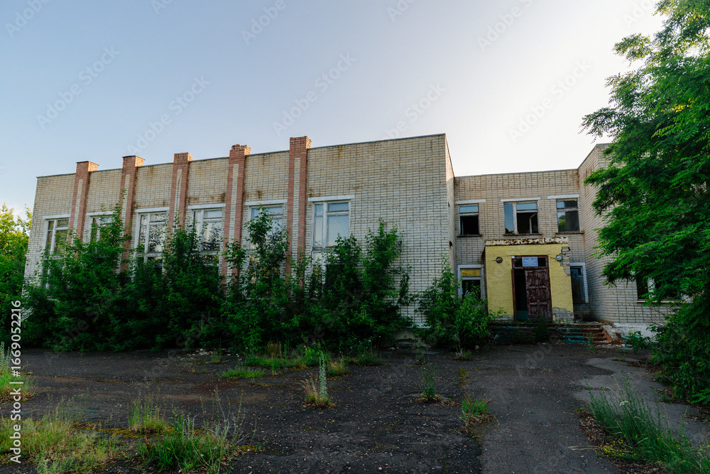Fototapeta premium Old ruined overgrown abandoned school