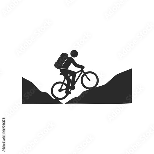 Silhouette of cyclist biking uphill in mountainous terrain