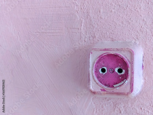 Vintage pink wall with rustic electrical outlet