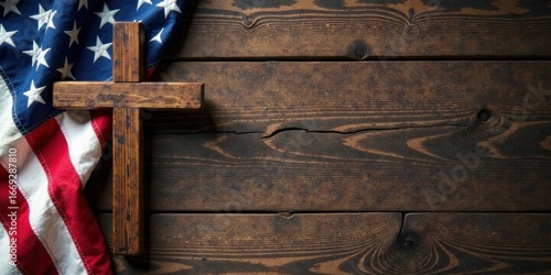 A rustic wooden cross rests on a dark wood surface, partially draped with a folded American flag, signifying faith and patriotism.