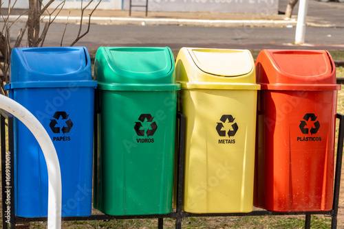 Colorful recycling bins for paper, glass, metal, and plastic in Brazil. Illustrates waste sorting, recycling, and environmental awareness.