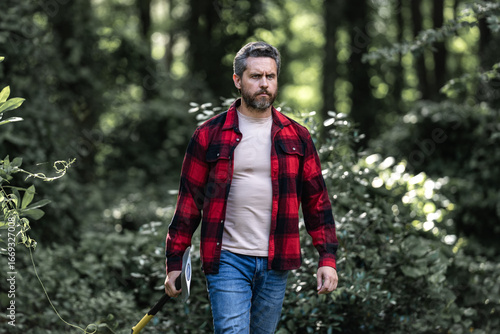 Wallpaper Mural Handsome man or lumberjack in checkered shirt hold axe. Lumberjack or woodman. Masculinity concept. Man brutal strong attractive guy cutting wood with axe in forest. Lumberjack with big axe in forest. Torontodigital.ca