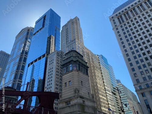 Modern Architectural Verticality in Chicago: A dramatic, upward-looking shot of a modern glass skyscraper, highlighting the clean lines and impressive height of contemporary architecture under a brigh