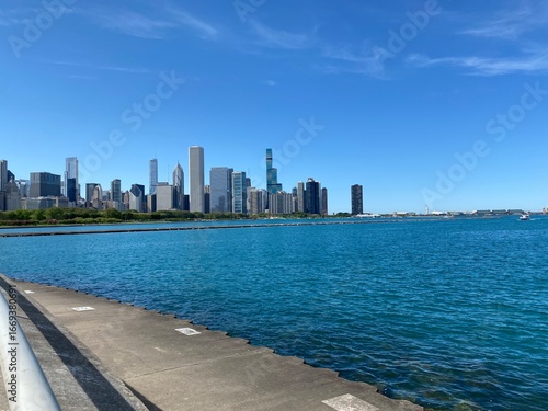 Chicago Skyline from Lake Michigan: A beautiful, wide-angle shot of the Chicago skyline as seen from the tranquil blue waters of Lake Michigan on a clear, sunny day.