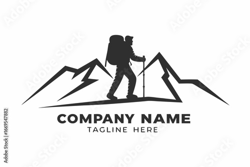 Silhouette of a hiker with backpack traverses mountain peak using trekking poles