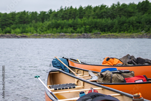 Принти на полотні Orange canoes with gear paused for backcountry lunch