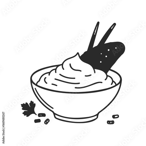 Creamy dip with crispy chip garnish in bowl with parsley accent